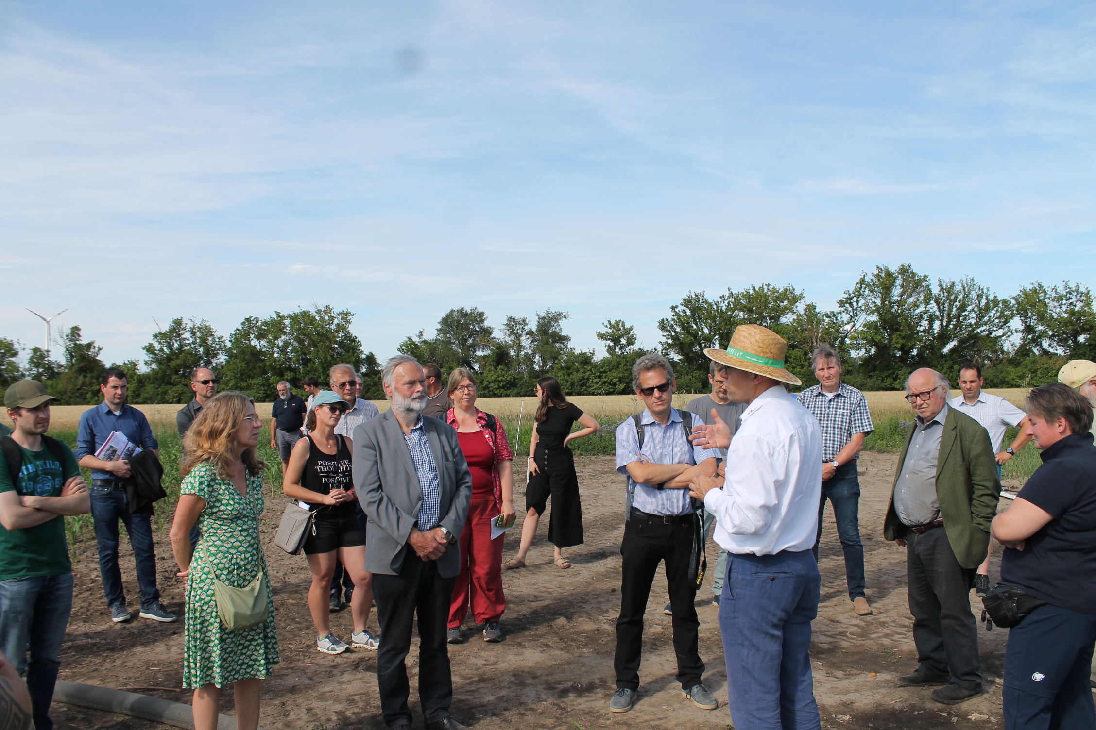 Menschen auf einem Feld die einem Vortrag zuhören